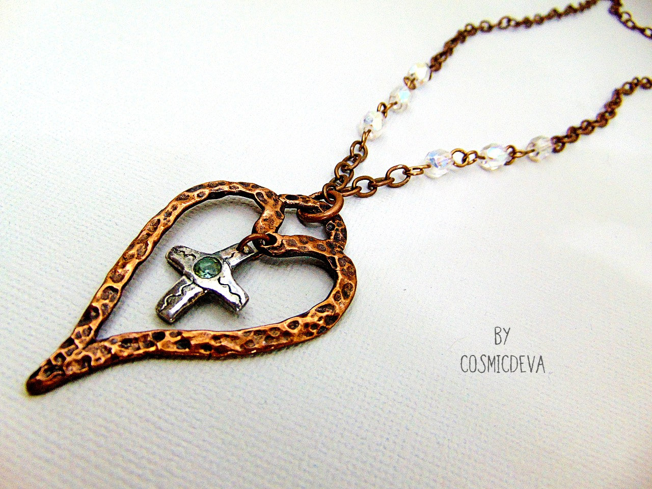 For The Love Of God - Express your faith in style and show your love for God with this beautiful handmade copper heart and sterling silver cross necklace, featuring an exquisite light blue topaz in the center. The deep warm finish and accentual aura white facetted Czech glass beads add a charming touch to your most special occasions.