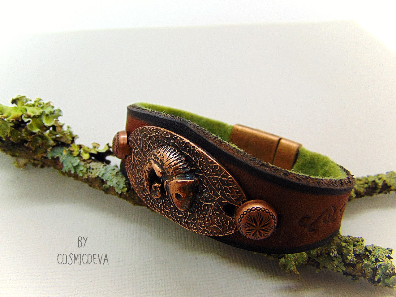 Unique handcrafted leather bracelet made of earthy brown dyed veg tan leather. The focal point is a hand sculptured solid copper chameleon on a textured solid copper base. The inside of the leather bracelet is lined with olive green felt for your comfort.