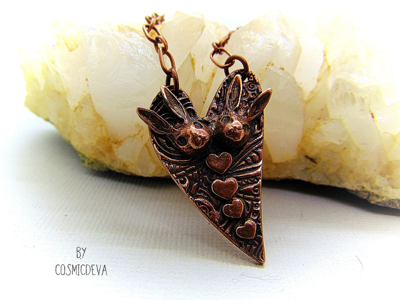 Cute one of a kind handmade unique bunny love heart pendant necklace. This rabbit pendant is heart shaped with to bunny heads and lots of tiny hearts. This gorgeous copper bunny heart pendant balances from a 18-inch – 21 inches chain with a copper lobster clasp closure. The pendant is hallmarked with the cosmicdeva logo on the backside. The wearable bunny art copper jewelry piece was oxidized for a deep warm finish and was sealed with renaissance wax.