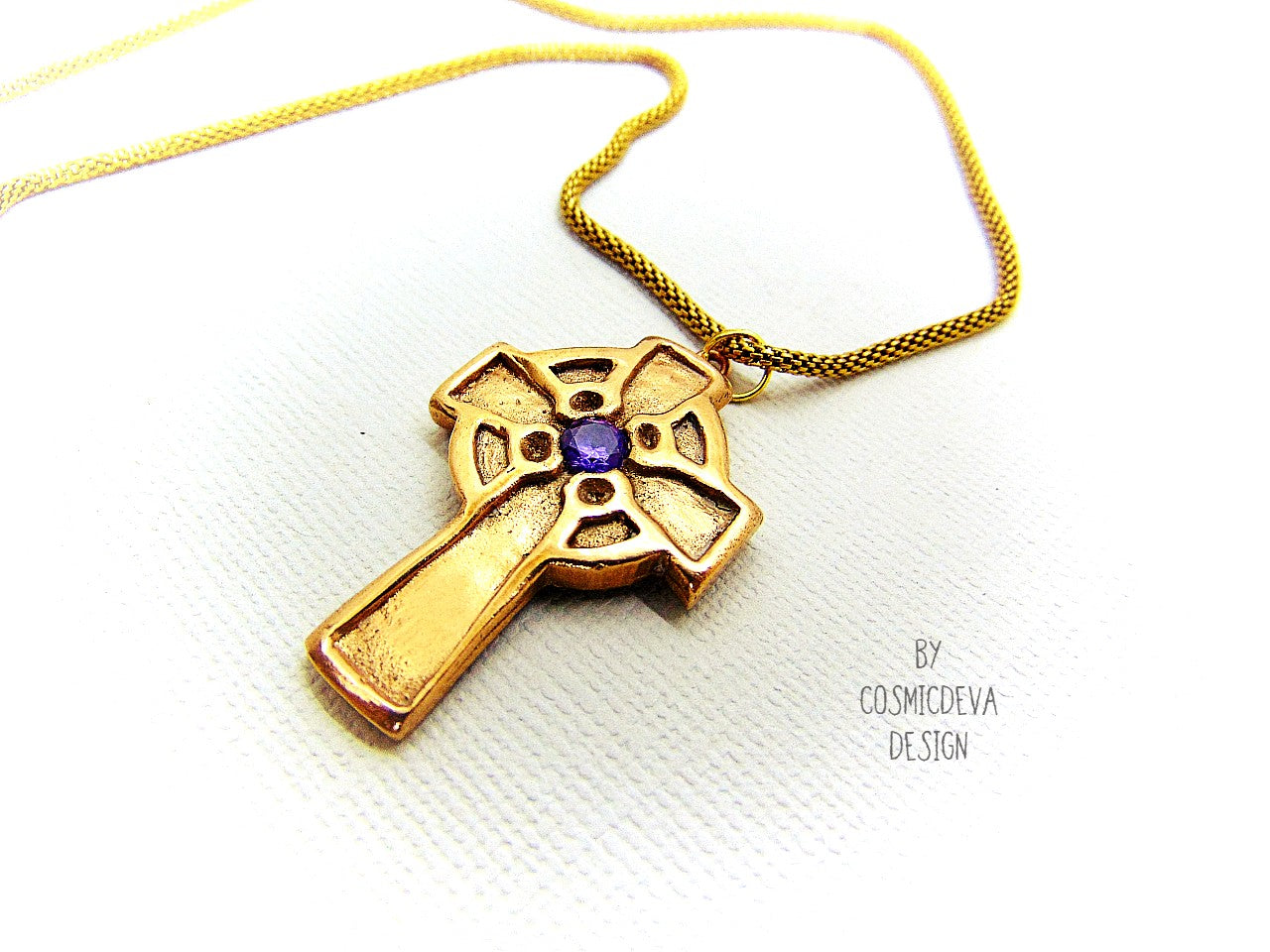 This handmade rustic Celtic Irish Cross pendant is made of solid gold bronze with a purple Amethyst in the center. The circle in the center represents the sun, an important item of worship in druid religion.