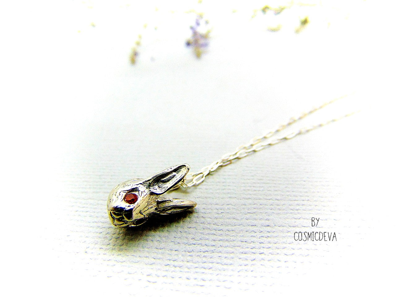 Handmade dainty small little rabbit 🐰 made of solid sterling silver with tiny faceted lab created fire opal eyes. Lab created stones are chemically, physically and optically identical to those mined underground. This cute little bunny dangles from a delicate 18 inch solid .925 sterling silver flat cable 1.4mm chain necklace.