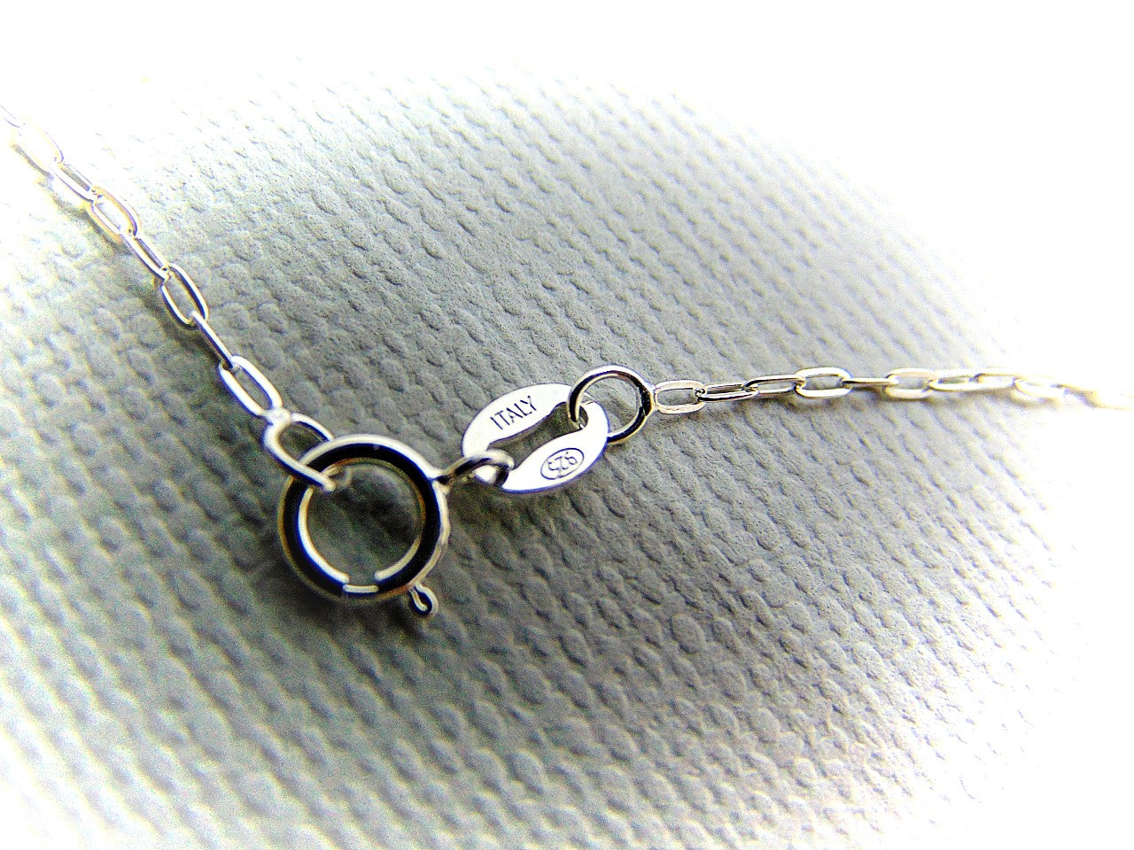 Handmade dainty small little rabbit 🐰 made of solid sterling silver with tiny faceted lab created fire opal eyes. Lab created stones are chemically, physically and optically identical to those mined underground. This cute little bunny dangles from a delicate 18 inch solid .925 sterling silver flat cable 1.4mm chain necklace.