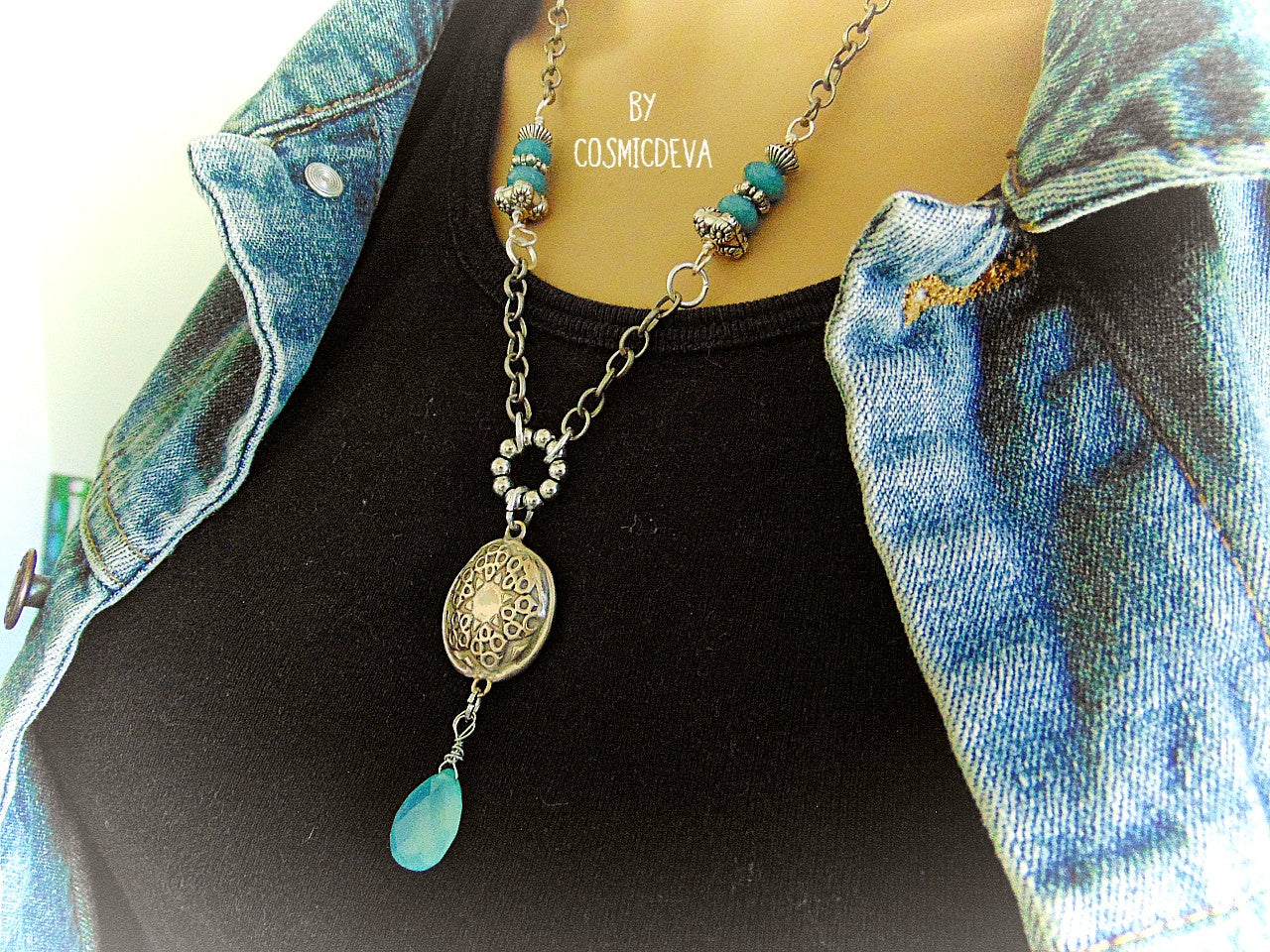 Beautiful handmade silver bronze lentil pendant with a mandala texture and a large faceted briolette aqua blue chalcedony gemstone dangle bead. The large hand formed lentil bead is double sided with two different designs and so can be worn facing either side. The pendant suspends from an 18 inch – 20-inch-long chain with accentual faceted Brazilian aquamarine abacus beads and Tibetan silver beads.