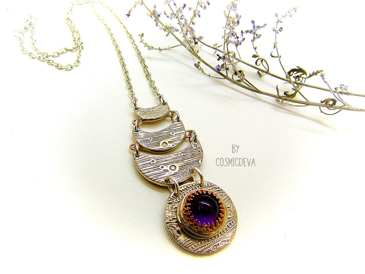Beautiful purple silver moon phase necklace with a natural amethyst cabochon as a focal point. This silver bronze crescent moon pendant was completely hand formed and kiln fired. Silver bronze has the look of sterling silver but for a more affordable price. The moon pendant suspends from an 18 inch – 20-inch-long chain.