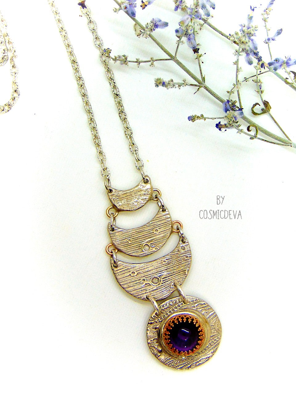 Beautiful purple silver moon phase necklace with a natural amethyst cabochon as a focal point. This silver bronze crescent moon pendant was completely hand formed and kiln fired. Silver bronze has the look of sterling silver but for a more affordable price. The moon pendant suspends from an 18 inch – 20-inch-long chain.