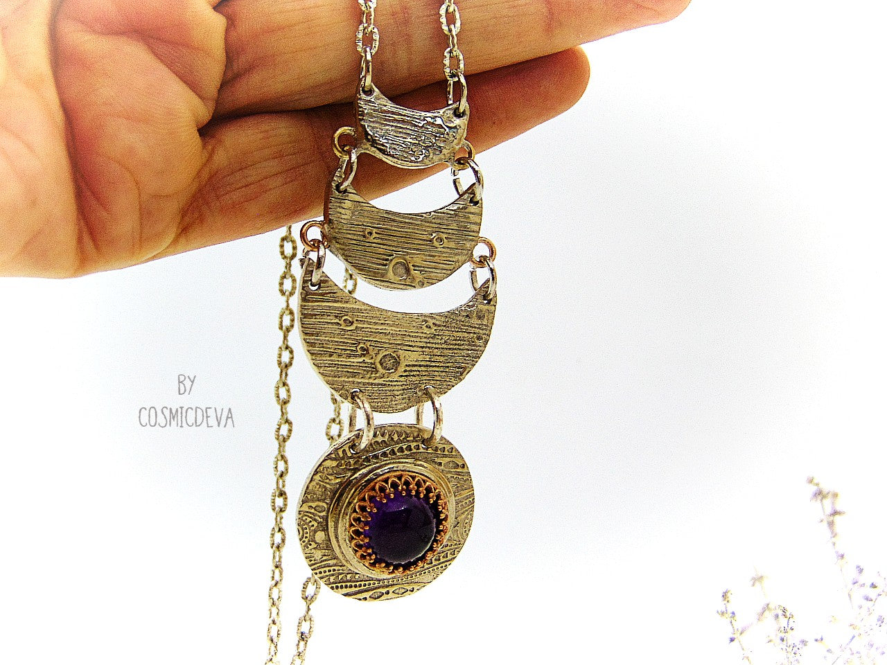 Beautiful purple silver moon phase necklace with a natural amethyst cabochon as a focal point. This silver bronze crescent moon pendant was completely hand formed and kiln fired. Silver bronze has the look of sterling silver but for a more affordable price. The moon pendant suspends from an 18 inch – 20-inch-long chain.