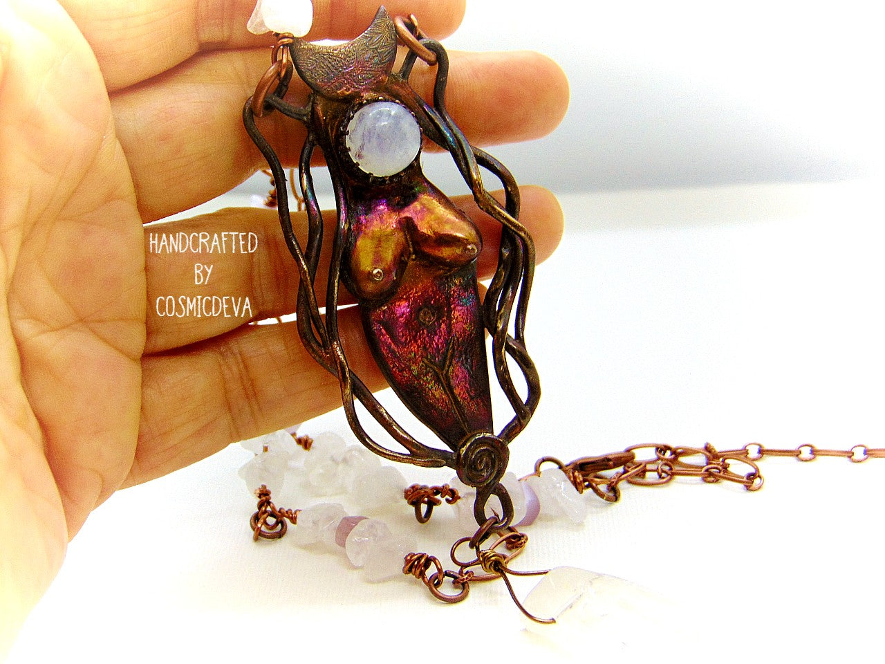 Lovely one-of-a-kind hand sculptured solid bronze organic primitive female divine energy goddess pendant featuring a moonstone and a dangling clear quartz crystal point. The pendant was oxidized to create this beautiful shimmering color tones. The handcrafted copper chain necklace features clear white quartz crystals and rose quartz.