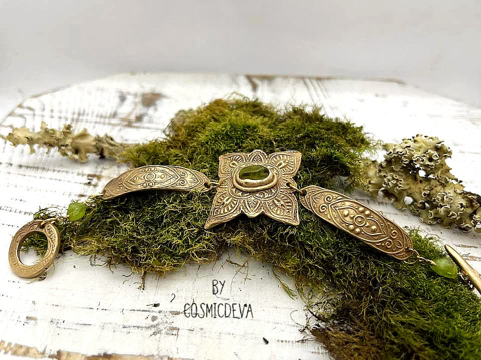 Feel enchanted by the earthy vibes of this Elven Bronze Medallion Bracelet with Raw Green Peridot. Hand formed with love, this medieval elven style bracelet is adorned with natural raw green peridot gemstones and a gracefully crafted toggle clasp.