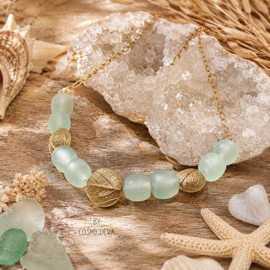 Experience nature-inspired elegance with this handcrafted Gold Bronze Leaf Necklace, featuring artisan bronze leaves imprinted from real leaves gathered from the artist’s own backyard. Recycled aqua blue glass beads add a soft coastal touch, creating a unique, sustainable botanical statement necklace perfect for boho and nature lovers.
