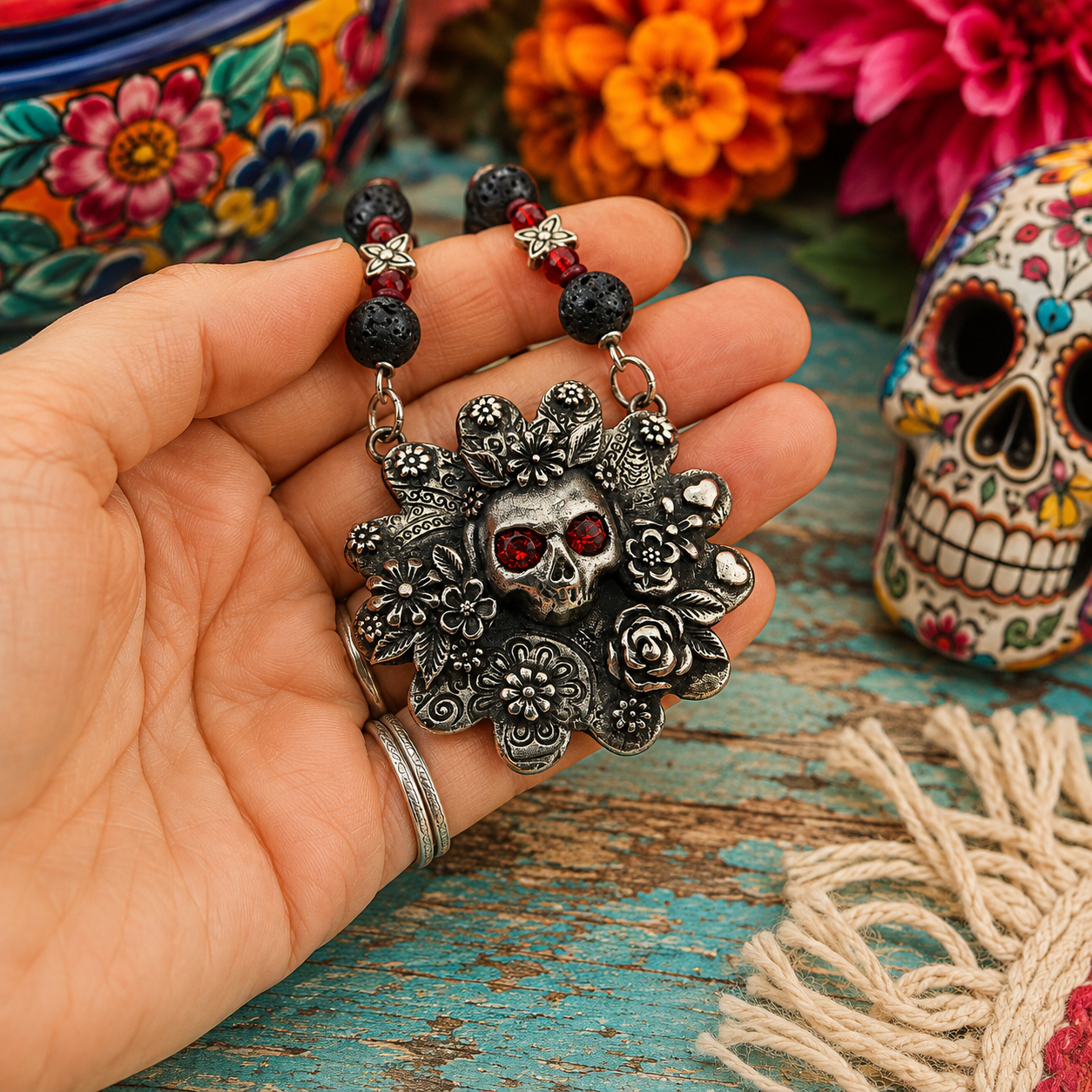 Cherish Mexican folk art with this unique Frida Kahlo sugar skull necklace, featuring a silver bronze floral pendant accented with garnet gemstones, roses, leaves and hearts.
