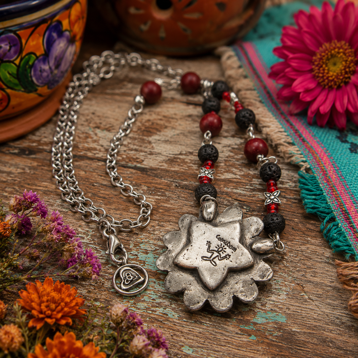 Cherish Mexican folk art with this unique Frida Kahlo sugar skull necklace, featuring a silver bronze floral pendant accented with garnet gemstones, roses, leaves and hearts.