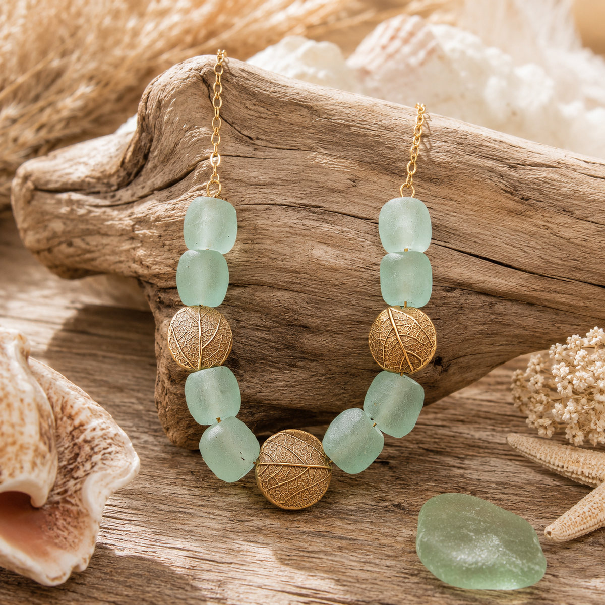 Experience nature-inspired elegance with this handcrafted Gold Bronze Leaf Necklace, featuring artisan bronze leaves imprinted from real leaves gathered from the artist’s own backyard. Recycled aqua blue glass beads add a soft coastal touch, creating a unique, sustainable botanical statement necklace perfect for boho and nature lovers.