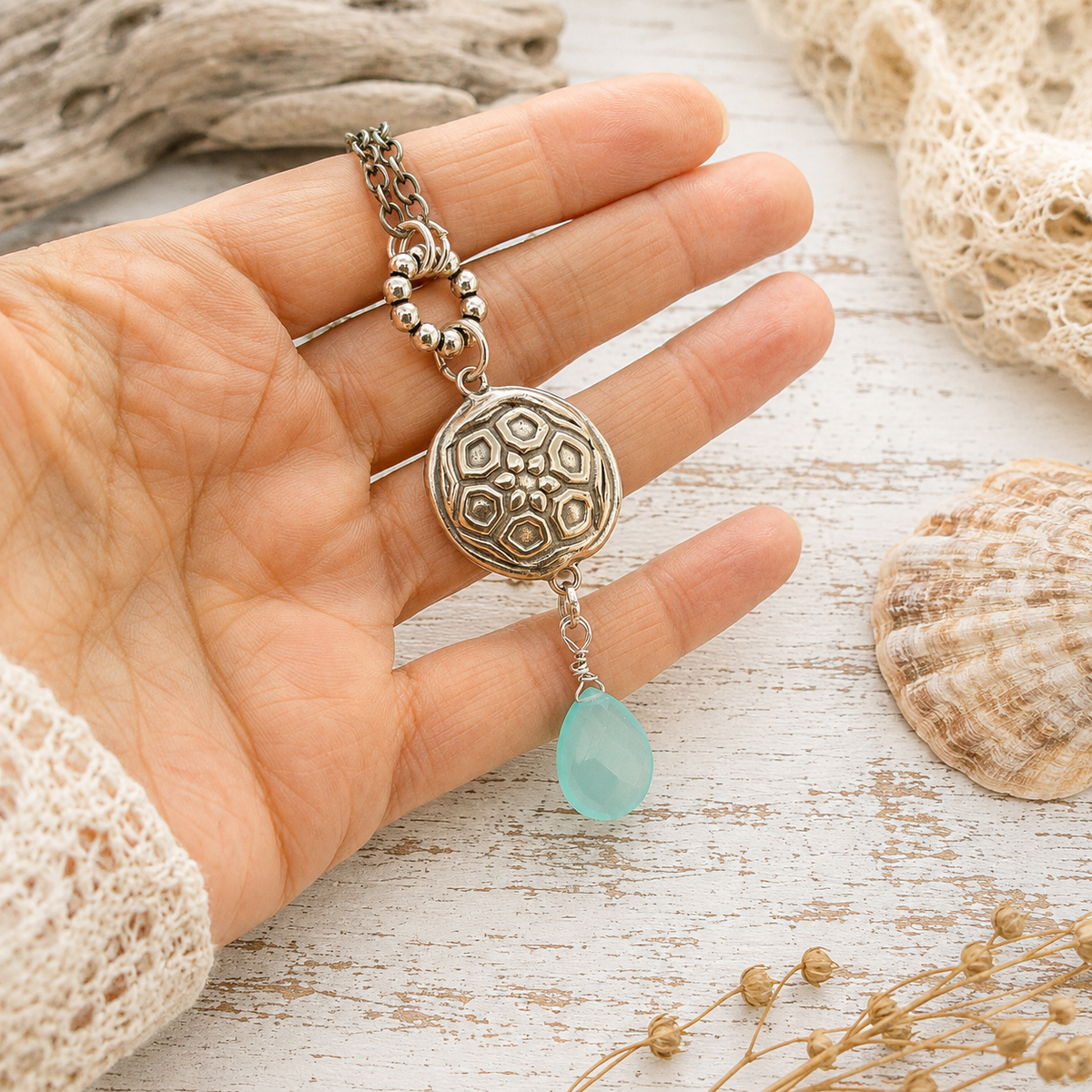 Handmade silver bronze mandala lentil pendant featuring an aqua blue chalcedony dangle, Brazilian aquamarine beads and Tibetan silver accents. A unique boho artisan necklace, adjustable from 18–20 inches.