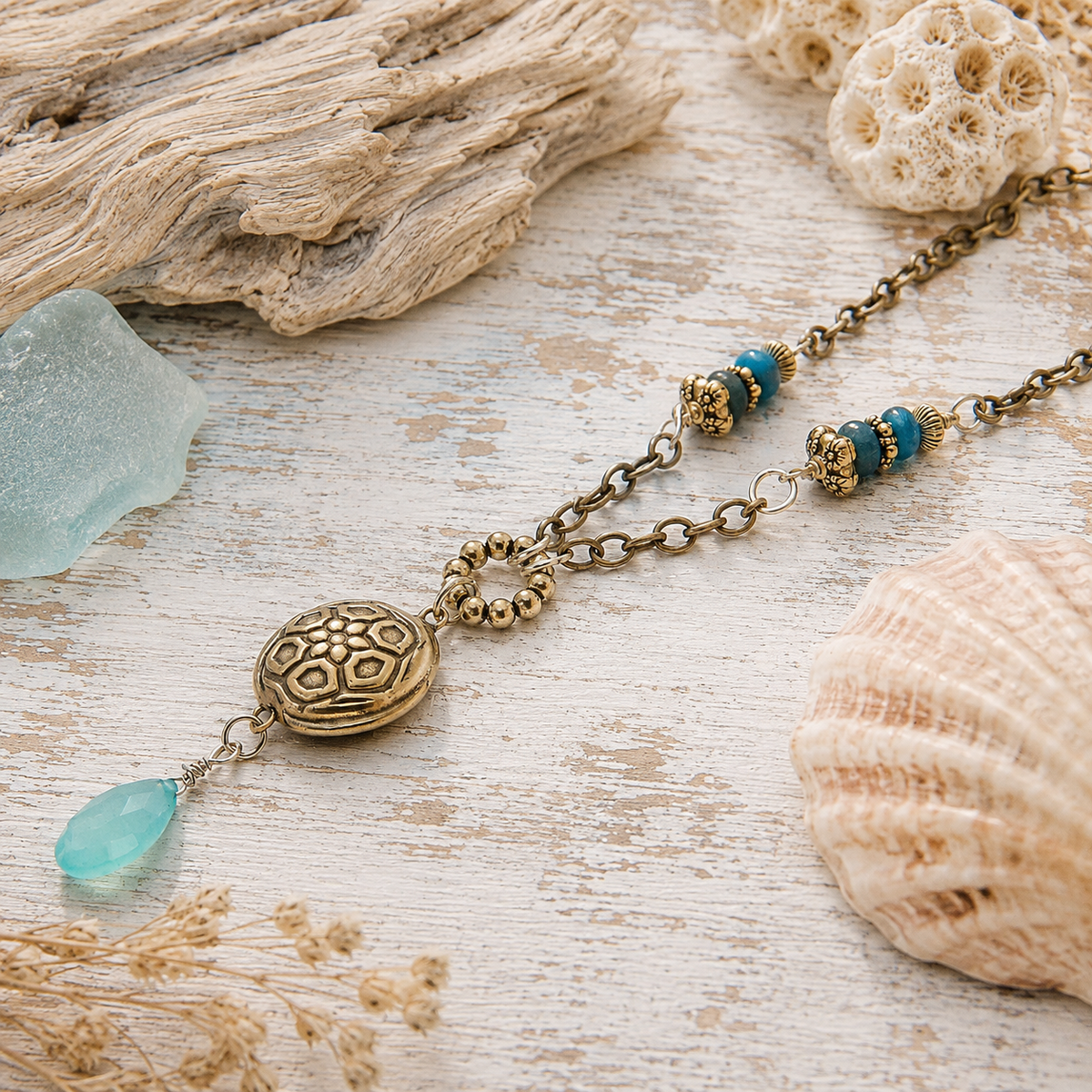 Handmade silver bronze mandala lentil pendant featuring an aqua blue chalcedony dangle, Brazilian aquamarine beads and Tibetan silver accents. A unique boho artisan necklace, adjustable from 18–20 inches.