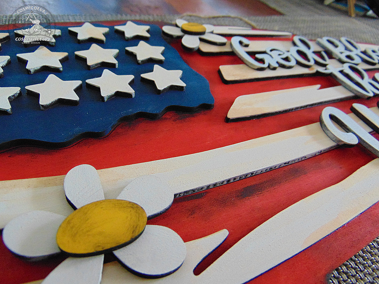 Handmade rustic American flag wall sign with layered laser-cut wood, distressed paint, and raised “God Bless the USA” lettering. Patriotic farmhouse décor perfect for July 4th or gifting.
