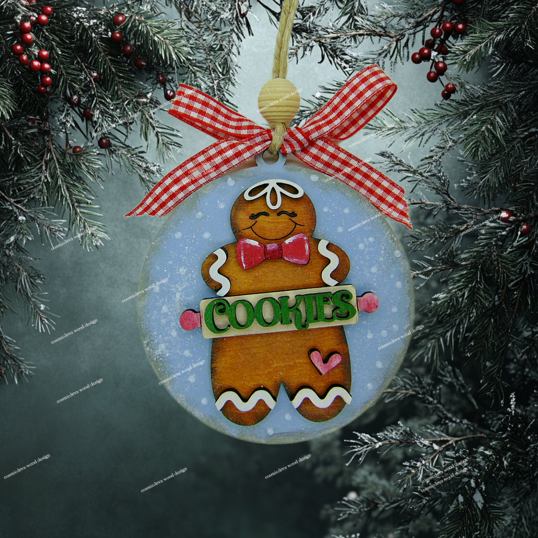 Hand painted wooden gingerbread man Christmas ornament with rolling pin “Cookies” cut out, blue sprinkle background, jute twine, wood bead, and checkered bow. Cute handmade holiday décor for bakers and cookie lovers.