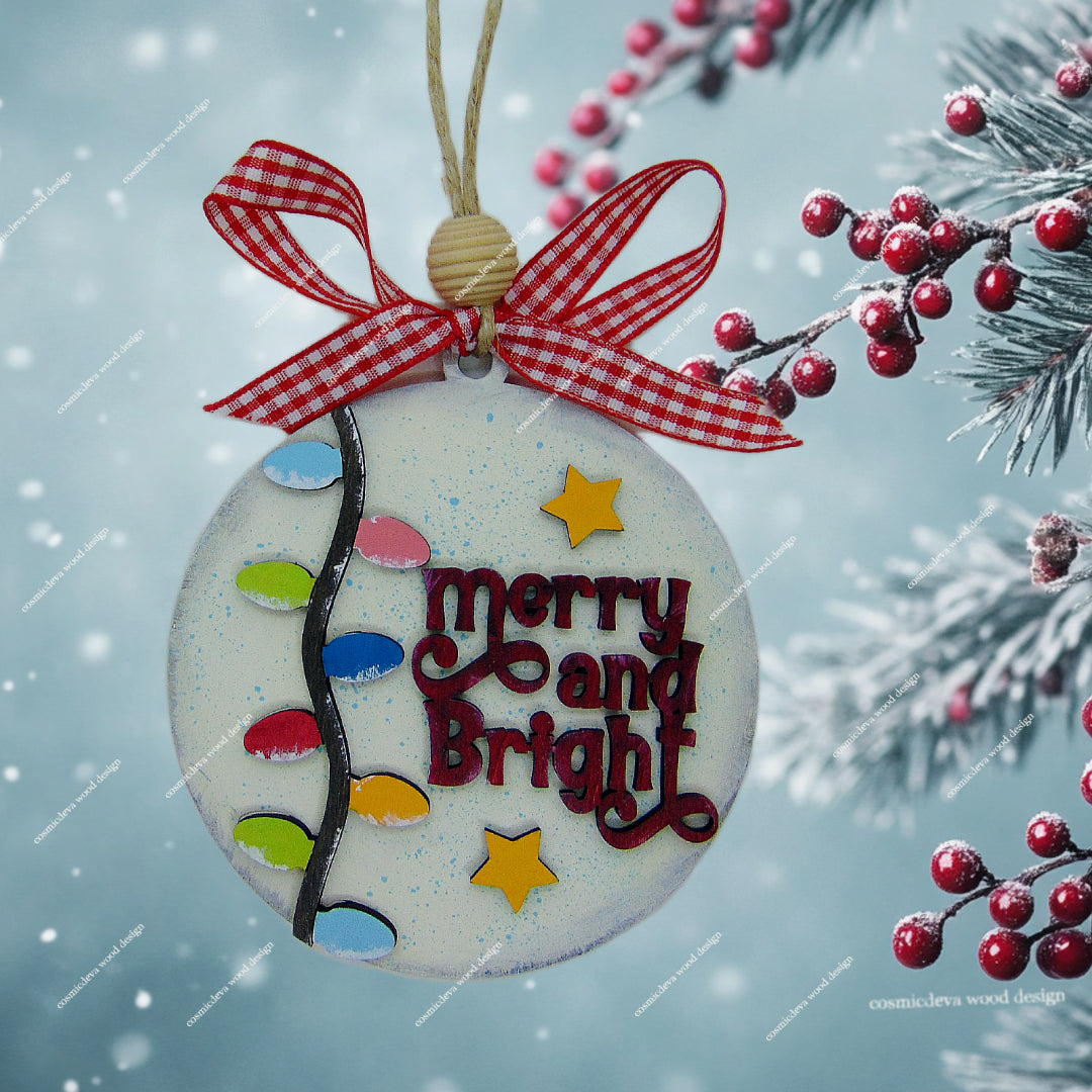 Hand painted layered birch wood Christmas ornament featuring fairy lights, stars, and “Merry & Bright” text. Rustic jute cord, handmade bow, and gift ready packaging. Lightweight, durable holiday décor.