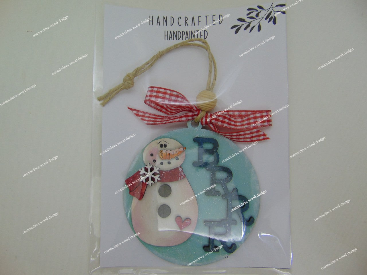 Add whimsical charm to your tree with our laser-cut Snowman Wood Ornament. Hand-painted with a red scarf and "Brrr" detail. High-quality 3.5" birch wood decor. Shop now!