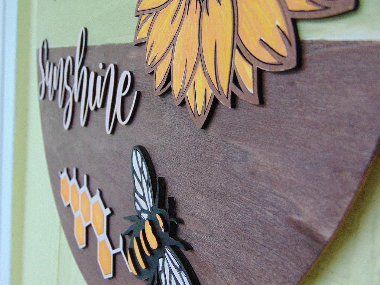 Brighten up your entryway this summer with our charming "Hello Sunshine" Sunflower Bee Door Hanger! This delightful piece is perfect for adding a touch of warmth and cheer to your front door, porch, or any space in your home. Each door hanger is lovingly handcrafted, ensuring that every piece is unique and may vary slightly from the picture, adding a personal touch to your decor.