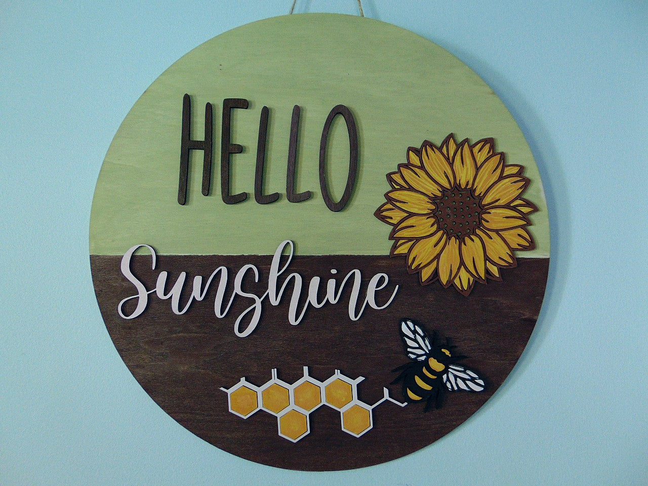 Brighten up your entryway this summer with our charming "Hello Sunshine" Sunflower Bee Door Hanger! This delightful piece is perfect for adding a touch of warmth and cheer to your front door, porch, or any space in your home. Each door hanger is lovingly handcrafted, ensuring that every piece is unique and may vary slightly from the picture, adding a personal touch to your decor.
