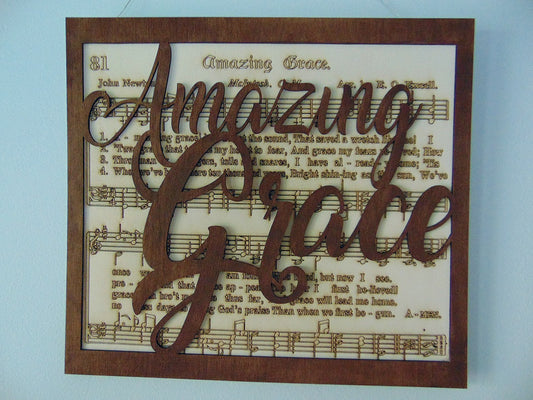 This handcrafted, laser-cut sign features the beloved hymn "Amazing Grace" with the sheet music and lyrics lasered into a light basswood backboard. The rich brown frame with "Amazing Grace" cut out over the backboard with a natural light basswood background, creating a stunning multi-layered effec