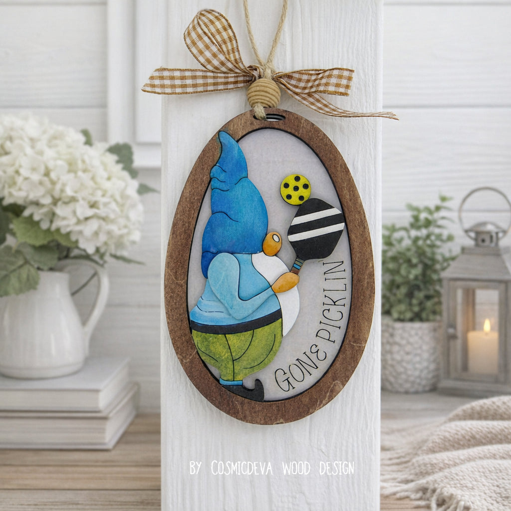 Hand painted 3D Pickleball Gnome Ornament with blue cap. Layered birch wood décor for year round pickleball lovers. Great gift for players, coaches, and fans.