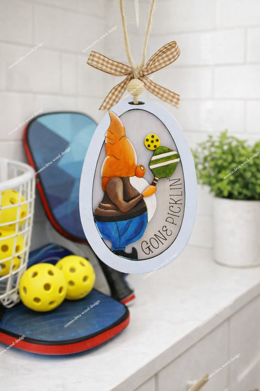 Hand painted 3D Pickleball Gnome Ornament with orange cap. Layered birch wood décor for year round pickleball lovers. Great gift for players, coaches, and fans.