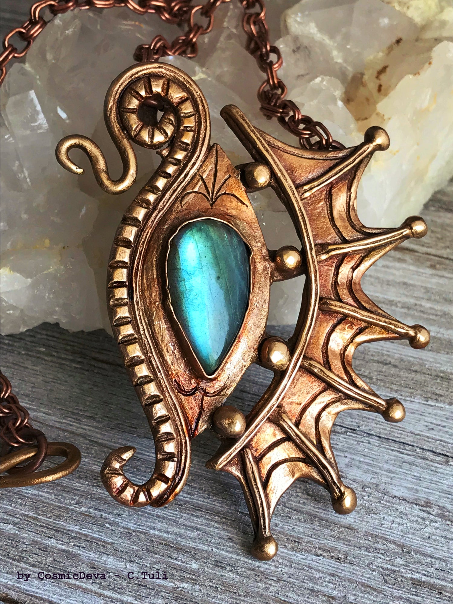 The Dragon is often seen as the guardian of a treasure. The treasure symbolizes you. This beautifully hand sculptured, carved, forged and kiln fired bronze pendant necklace symbolizes the Eye of a Dragon featuring a magical mystical shimmering labradorite gemstone. The reverse of the pendant is signed by the artist and carries the CosmicDeva brand hallmark.- CosmicDeva