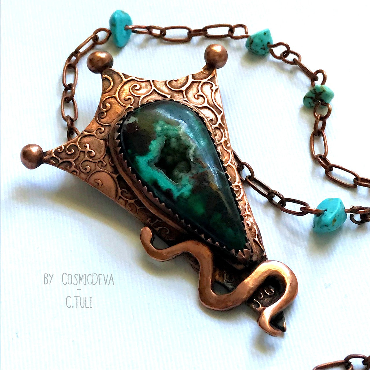Botryoidal Chrysocolla Copper Snake Pendant Necklace This unique Chrysocolla with Malachite and traces of cuprite gemstone is nestled amidst a complete hand sculptured triangle pendant with a little snake winding up in rich and warm glowing copper and has beautiful swirl texture. This rustic copper statement necklace suspends from a copper chain with natural turquoise beads. The copper jewelry piece was oxidized for a deep warm finish.- CosmicDeva