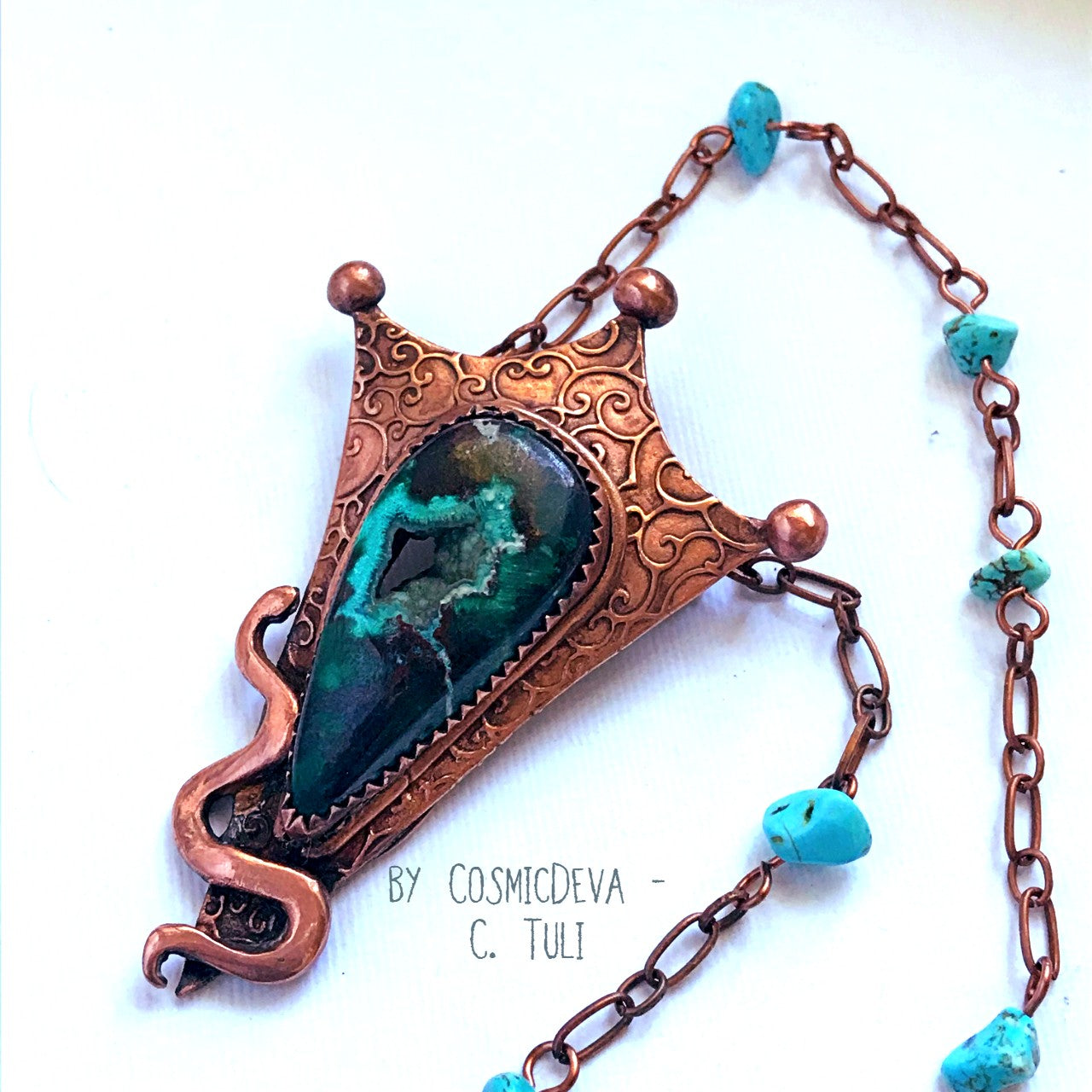 This unique Chrysocolla with Malachite and traces of cuprite gemstone is nestled amidst a complete hand sculptured triangle pendant with a little snake winding up in rich and warm glowing copper and has beautiful swirl texture. This rustic copper statement necklace suspends from a copper chain with natural turquoise beads. The copper jewelry piece was oxidized for a deep warm finish. Botryoidal Chrysocolla Copper Snake Pendant Necklace - CosmicDeva