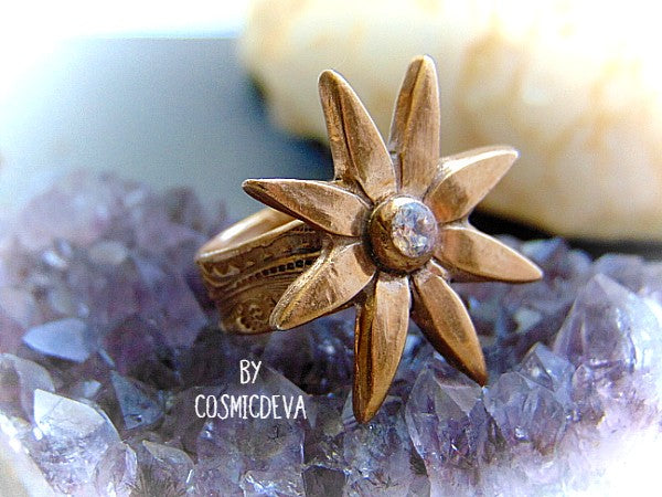 Add some sparkle to your life with this beautiful Flower Cocktail Ring! Handcrafted with a solid gold bronze setting and a dazzling cubic zirconia gemstone, this statement ring will make your look shine! Upgrade your wardrobe - and your confidence - today!- CosmicDeva