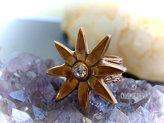 Add some sparkle to your life with this beautiful Flower Cocktail Ring! Handcrafted with a solid gold bronze setting and a dazzling cubic zirconia gemstone, this statement ring will make your look shine! Upgrade your wardrobe - and your confidence - today!   - CosmicDeva