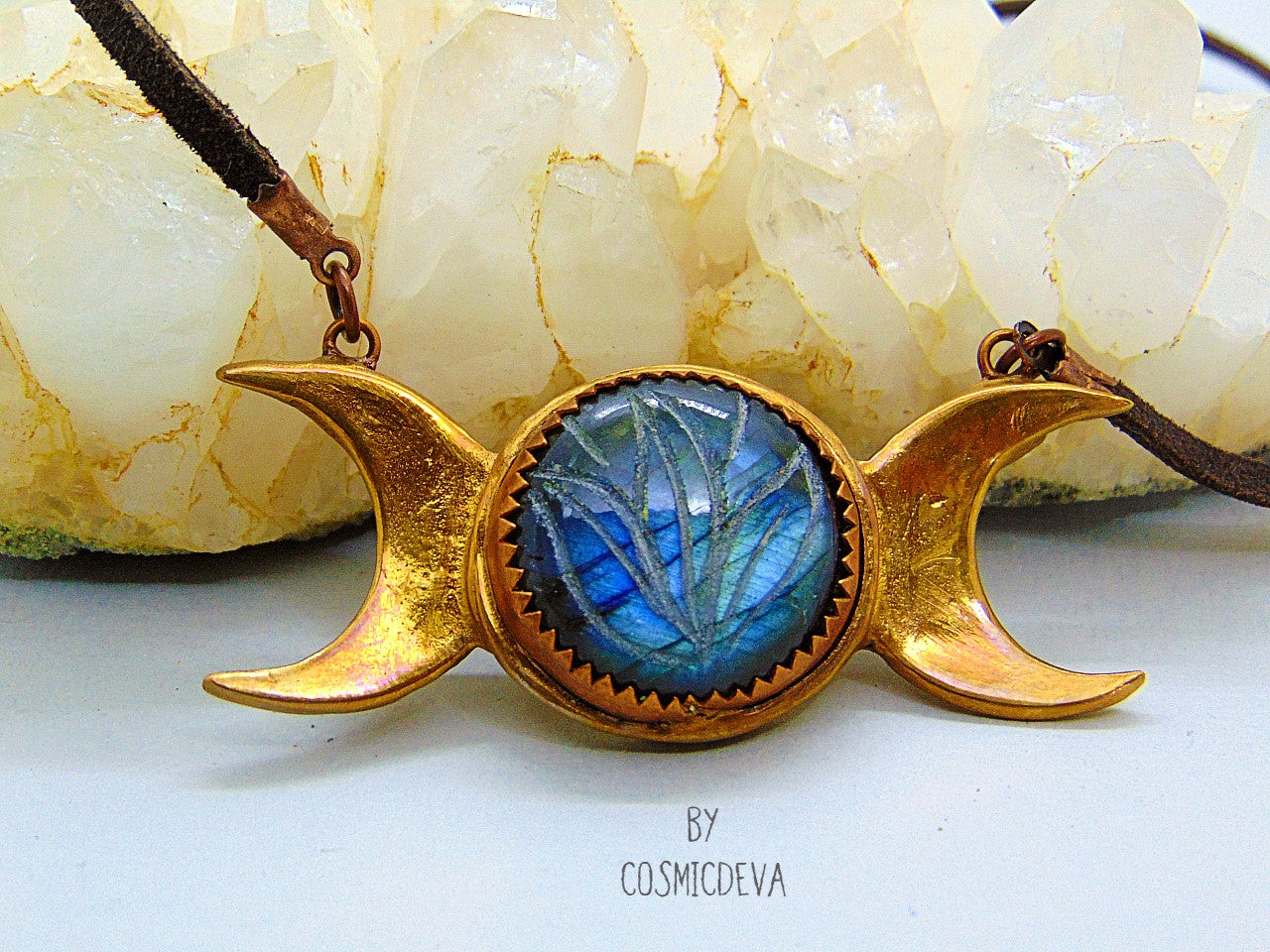 Wear the Triple Moon Goddess necklace as a powerful reminder of your connection to the divine feminine. Crafted with pure gold bronze and featuring a stunning blue labradorite gemstone with a floral engravement.- CosmicDeva