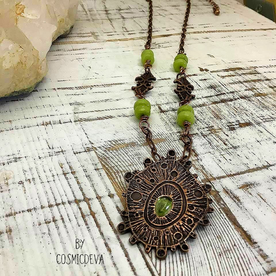Draw attention with this unique one-of-a-kind handmade copper pendant necklace, featuring a stunning peridot gemstone at its center. Oxidized for a warm, deep finish and suspended by light olive-green jade beads, it's a magnificent piece of art that will add a special touch of glamour to any occasion. Wear it and make an unforgettable impression!- CosmicDeva