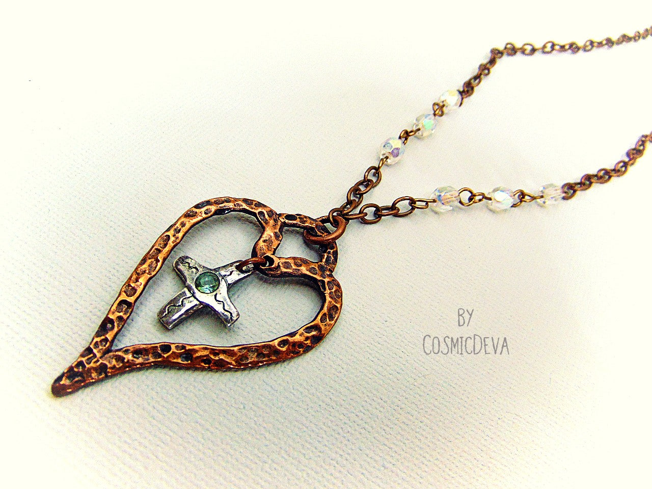 For The Love Of God - Express your faith in style and show your love for God with this beautiful handmade copper heart and sterling silver cross necklace, featuring an exquisite light blue topaz in the center. The deep warm finish and accentual aura white facetted Czech glass beads add a charming touch to your most special occasions.