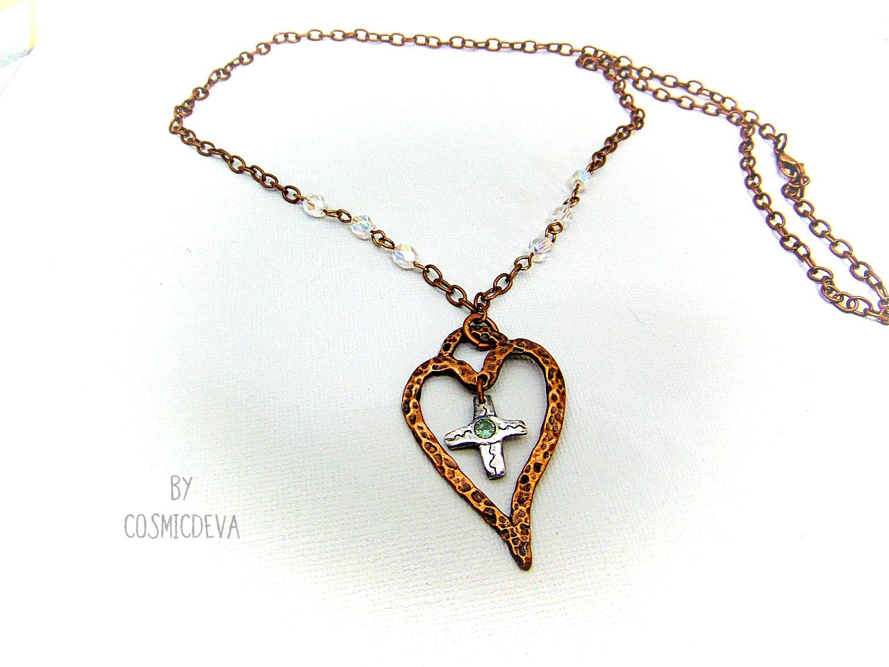 For The Love Of God - Express your faith in style and show your love for God with this beautiful handmade copper heart and sterling silver cross necklace, featuring an exquisite light blue topaz in the center. The deep warm finish and accentual aura white facetted Czech glass beads add a charming touch to your most special occasions.