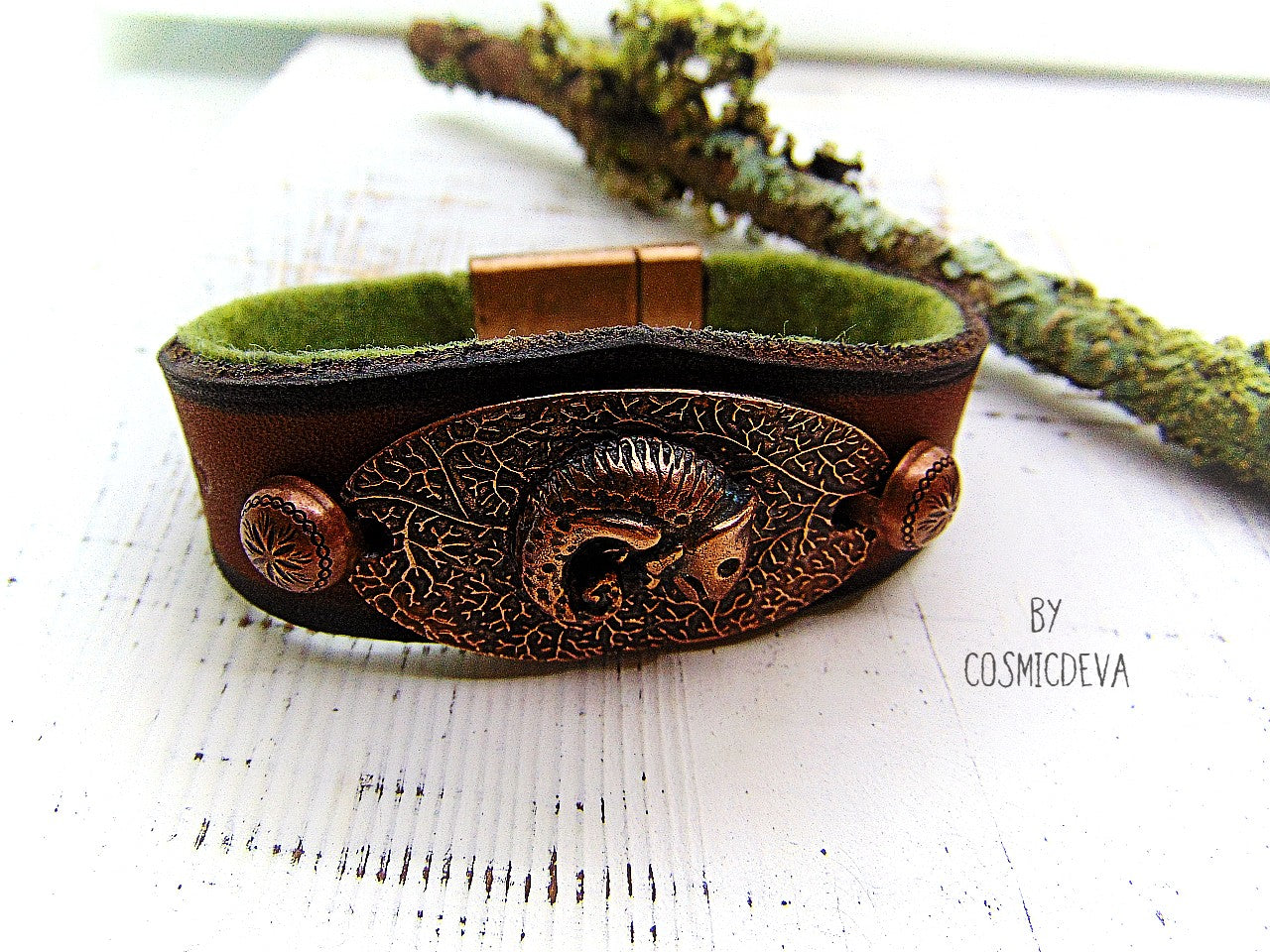 Unique handcrafted leather bracelet made of earthy brown dyed veg tan leather. The focal point is a hand sculptured solid copper chameleon on a textured solid copper base. The inside of the leather bracelet is lined with olive green felt for your comfort.