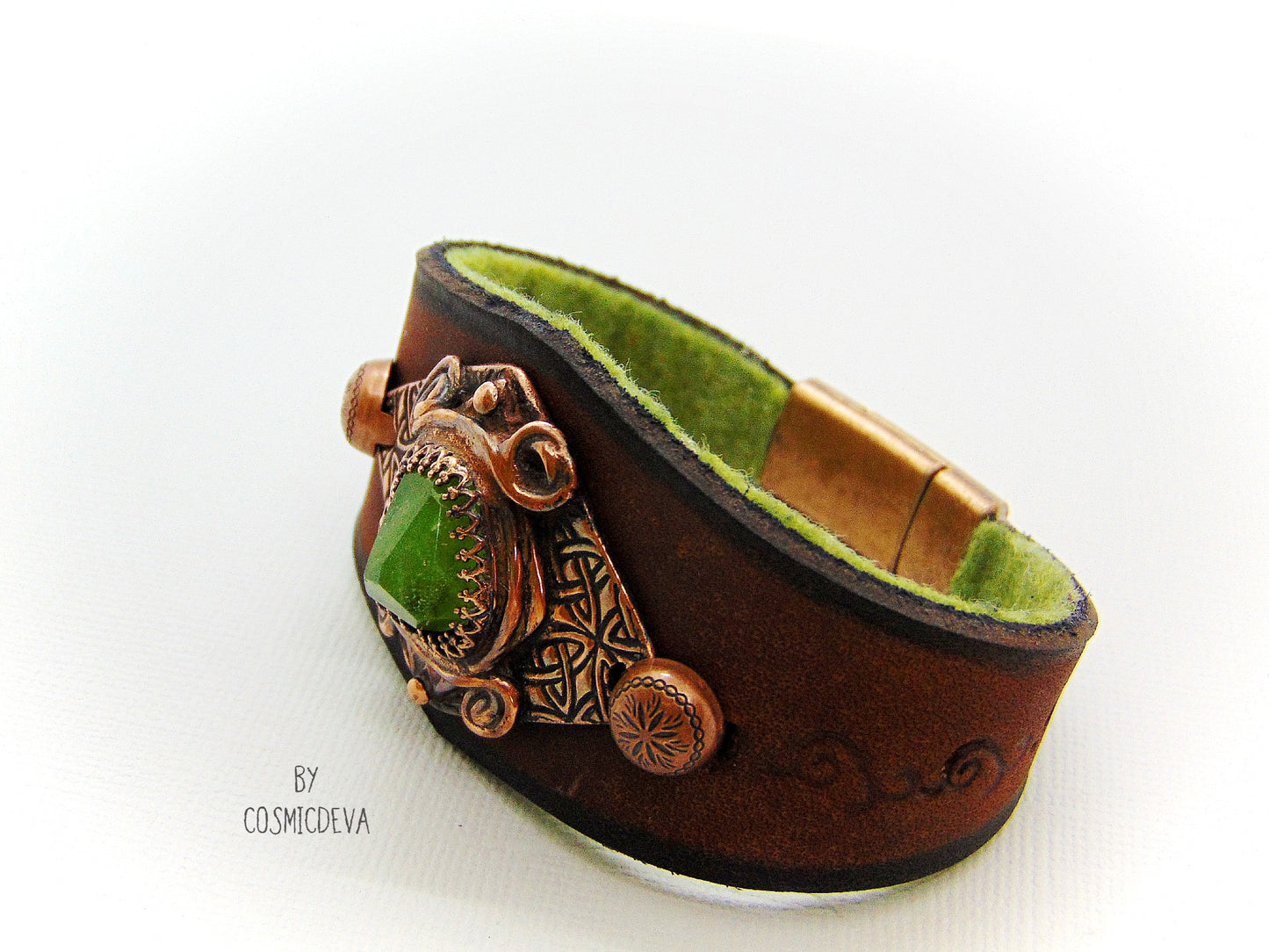 One of a kind handcrafted leather cuff bracelet made of hand cut earthy brown dyed veg tan leather. The focal point is a high quality natural raw green peridot gemstone in a bezel setting on a Celtic design textured solid copper base. The inside of the leather bracelet is lined with olive green felt for your comfort. cosmicdeva