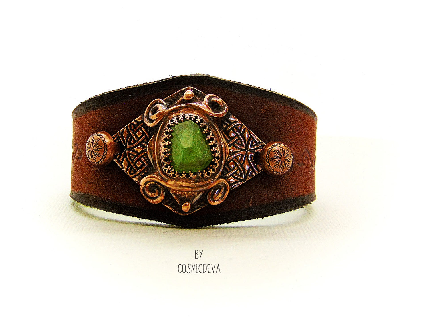 One of a kind handcrafted leather cuff bracelet made of hand cut earthy brown dyed veg tan leather. The focal point is a high quality natural raw green peridot gemstone in a bezel setting on a Celtic design textured solid copper base. The inside of the leather bracelet is lined with olive green felt for your comfort.