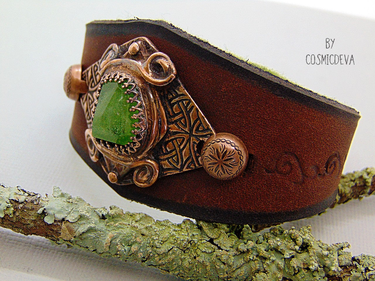 One of a kind handcrafted leather cuff bracelet made of hand cut earthy brown dyed veg tan leather. The focal point is a high quality natural raw green peridot gemstone in a bezel setting on a Celtic design textured solid copper base. The inside of the leather bracelet is lined with olive green felt for your comfort. Cosmicdeva