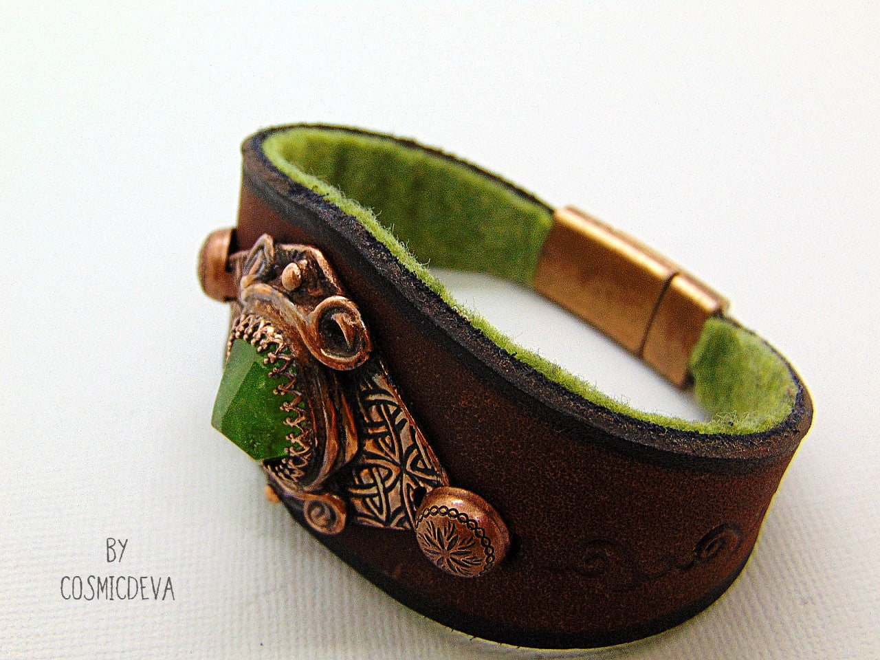 One of a kind handcrafted leather cuff bracelet made of hand cut earthy brown dyed veg tan leather. The focal point is a high quality natural raw green peridot gemstone in a bezel setting on a Celtic design textured solid copper base. The inside of the leather bracelet is lined with olive green felt for your comfort. Cosmicdeva
