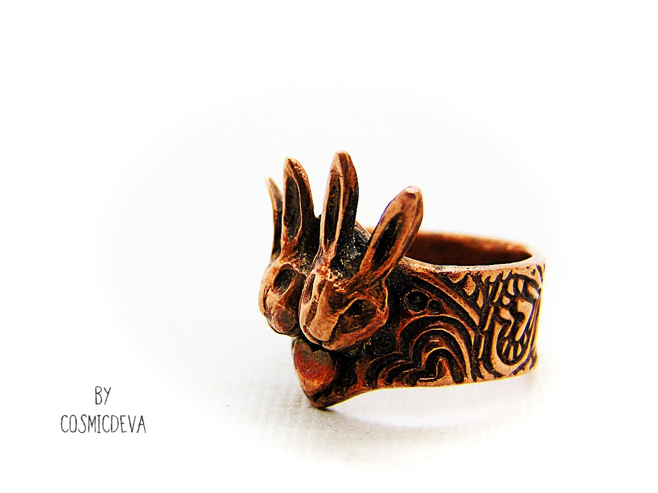 Love bunnies? Show your devotion with this gorgeous Copper Bunny Love Ring! Crafted by hand, it features two snuggled bunny heads with a heart in the middle, plus a textured shank and a heart on the back. One-of-a-kind and unique, this US Size 7.5 Ring is perfect for expressing your style and your bunny appreciation!