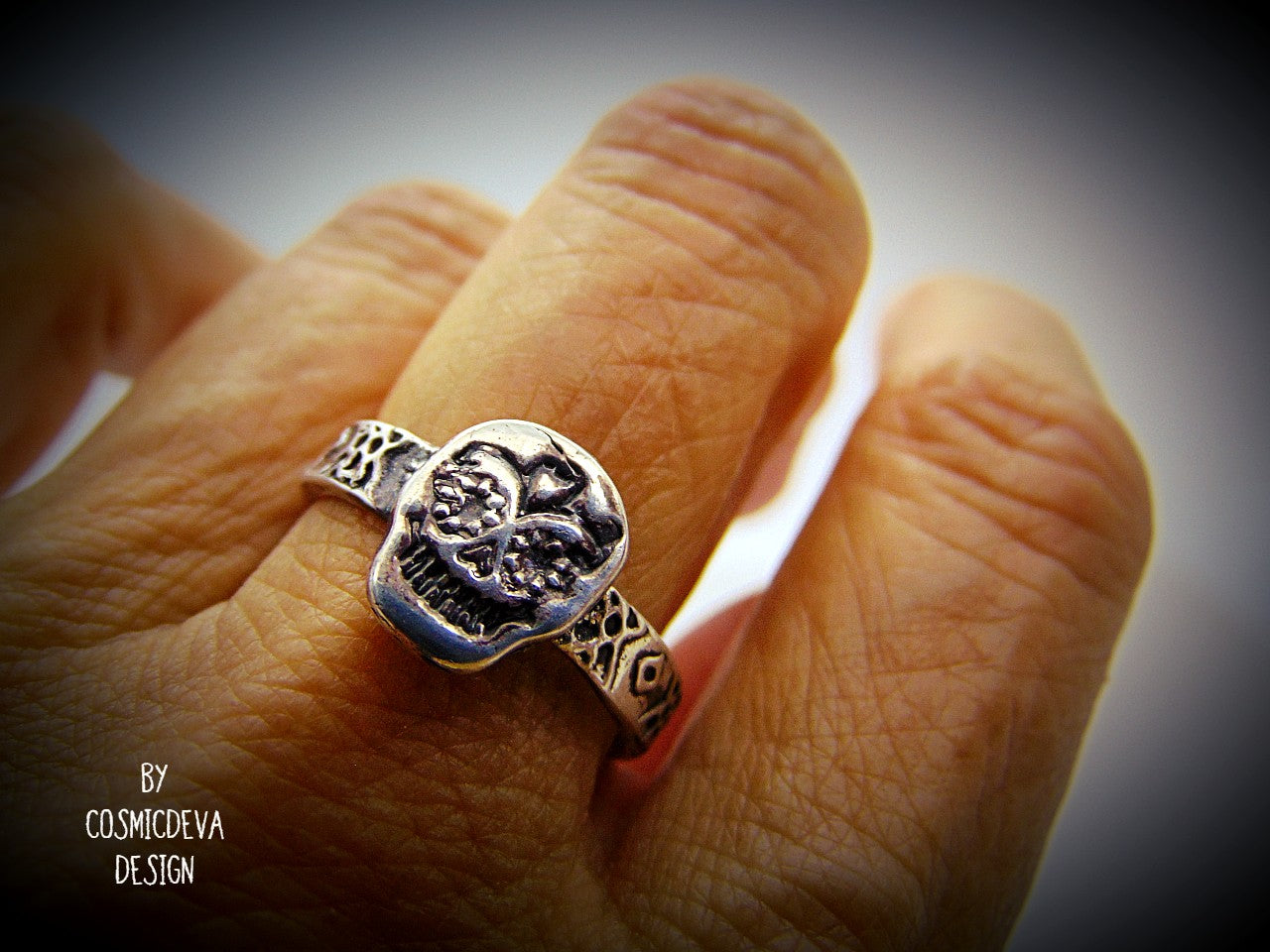 Handmade cute dainty sugar scull sterling silver ring. The inside of the ring has a polish with a few small irregularities from the forming process. The sterling silver sugar scull ring has been oxidized. The sugar skull is the predominant symbol of the "Day of the Dead", or Día de Los Muertos in Mexican culture. 