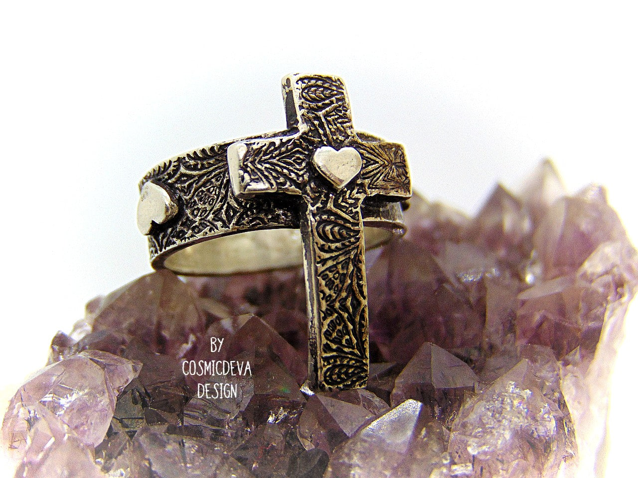 Completely handcrafted solid sterling silver cross ring. The surface of the ring features a rich oxidized textured cross with a heart in the center of the cross. The heart symbol in the center of the cross and on the sides of the ring shank is a reminder that Christ as a foundation is built on love – all the love we have for others should be unconditional in the same way he loves us. Love each other as I have loved you – John 15:12.