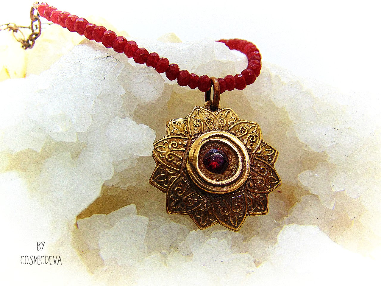 Celebrate your spiritual side with this unique Red Ruby Mandala Mendhi Gold Bronze Necklace. Crafted with a hand-formed bronze pendant, a stunning faceted lab-created ruby gemstone, and adorned with small red jade rondelle beads, this one of a kind necklace is an inspired homage to Indian Mehndi culture. Fall in love with the beauty and mystery of this spiritual accessory!