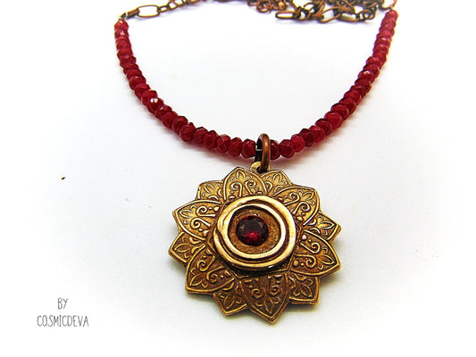 Celebrate your spiritual side with this unique Red Ruby Mandala Mendhi Gold Bronze Necklace. Crafted with a hand-formed bronze pendant, a stunning faceted lab-created ruby gemstone, and adorned with small red jade rondelle beads, this one of a kind necklace is an inspired homage to Indian Mehndi culture. Fall in love with the beauty and mystery of this spiritual accessory!