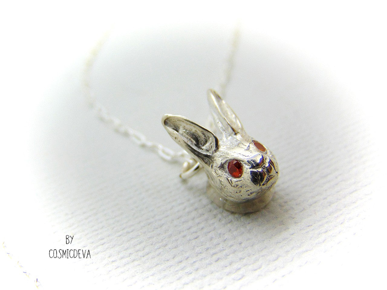 Handmade dainty small little rabbit 🐰 made of solid sterling silver with tiny faceted lab created fire opal eyes. Lab created stones are chemically, physically and optically identical to those mined underground. This cute little bunny dangles from a delicate 18 inch solid .925 sterling silver flat cable 1.4mm chain necklace.