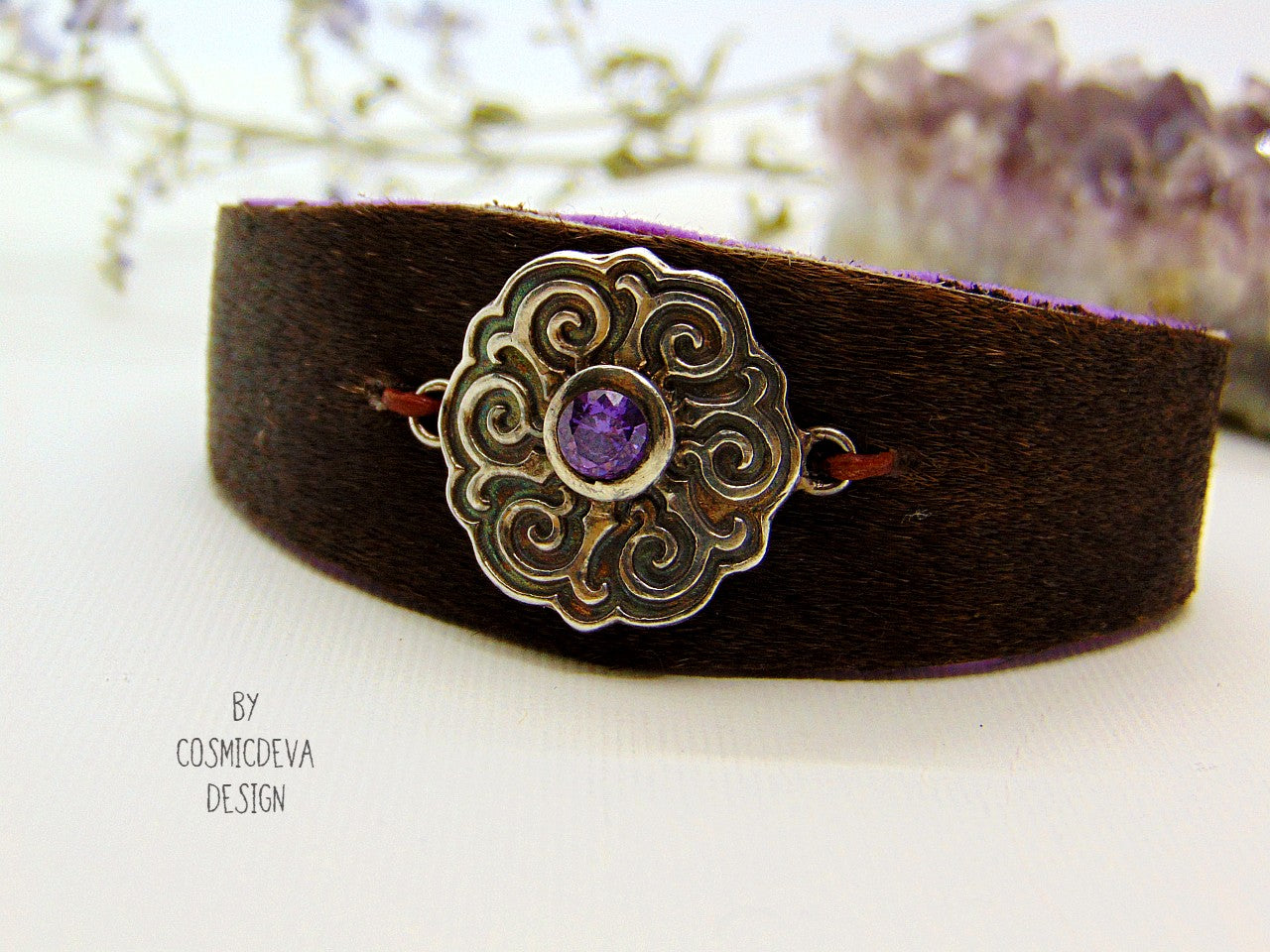 One of a kind handcrafted leather cuff bracelet made of hand cut earthy brown hair on cowhide leather. The focal point is a purple cubic zirconia amethyst in a bezel setting on a Celtic design textured solid 950 sterling silver disc. The inside of the leather bracelet is lined light purple/ lilac felt for your comfort. The handmade bracelet has silver colored stainless steel magnetic clasp which makes it easy to open and close.