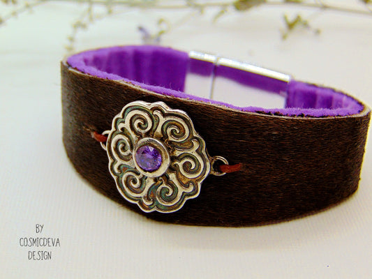 One of a kind handcrafted leather cuff bracelet made of hand cut earthy brown hair on cowhide leather. The focal point is a purple cubic zirconia amethyst in a bezel setting on a Celtic design textured solid 950 sterling silver disc. The inside of the leather bracelet is lined light purple/ lilac felt for your comfort. The handmade bracelet has silver colored stainless steel magnetic clasp which makes it easy to open and close.