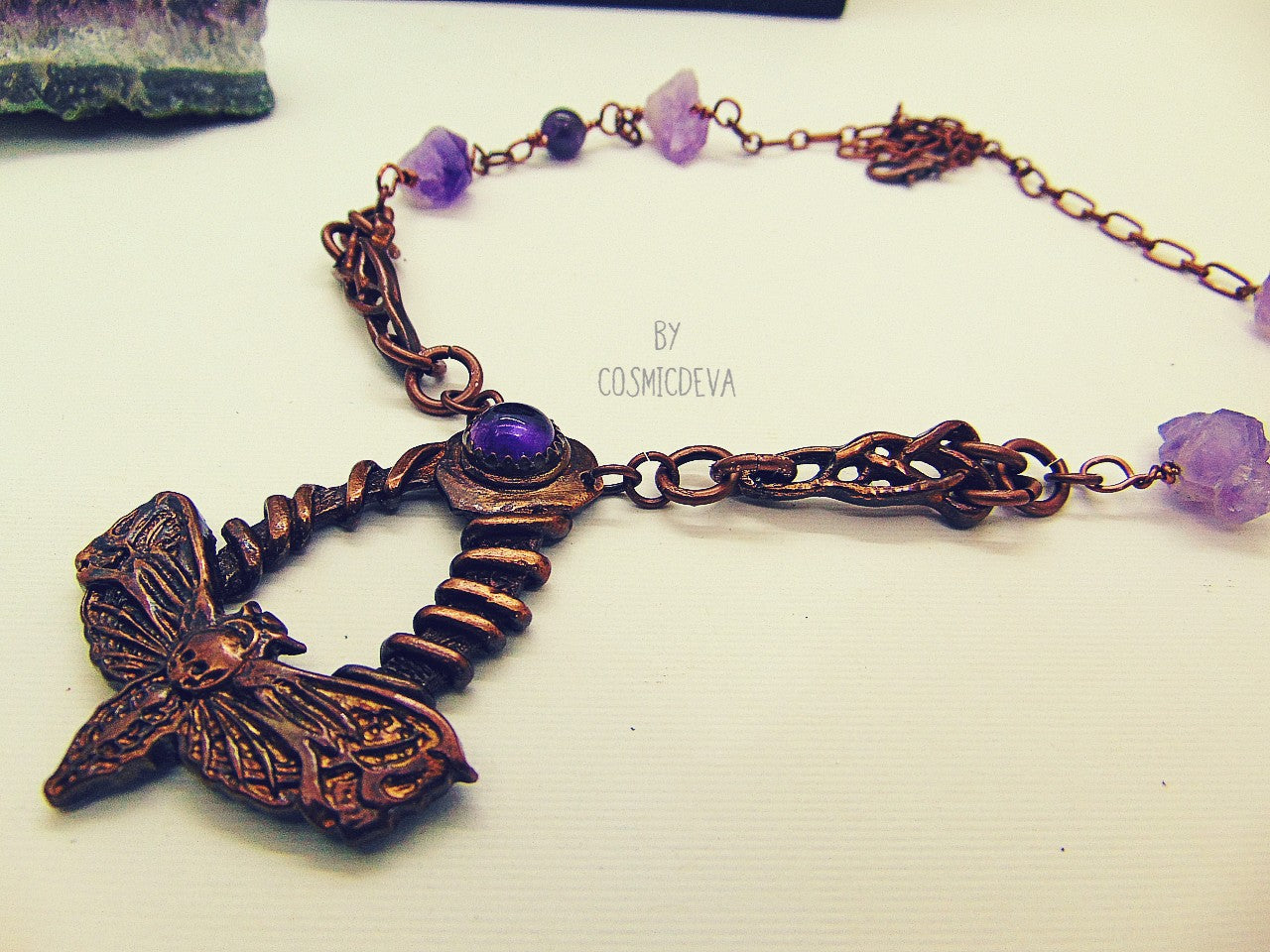 Handcrafted detailed death head hawk Moth (Acherontia) made of solid copper with a natural amethyst cabochon setting. The pendant is the focal point of a chain necklace with drilled natural raw amethyst gemstones, natural amethyst round beads and two completely handcrafted copper Celtic knot design findings.